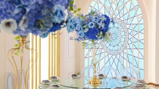 A table with glassware and a decorative blue floral arrangement. - Shuixiu Boutique Hotel (Quwo)
