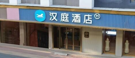 Un hotel con un cartello che riporta la scritta 'ę±åŗé
åŗ' e un logo raffigurante un cavallo.