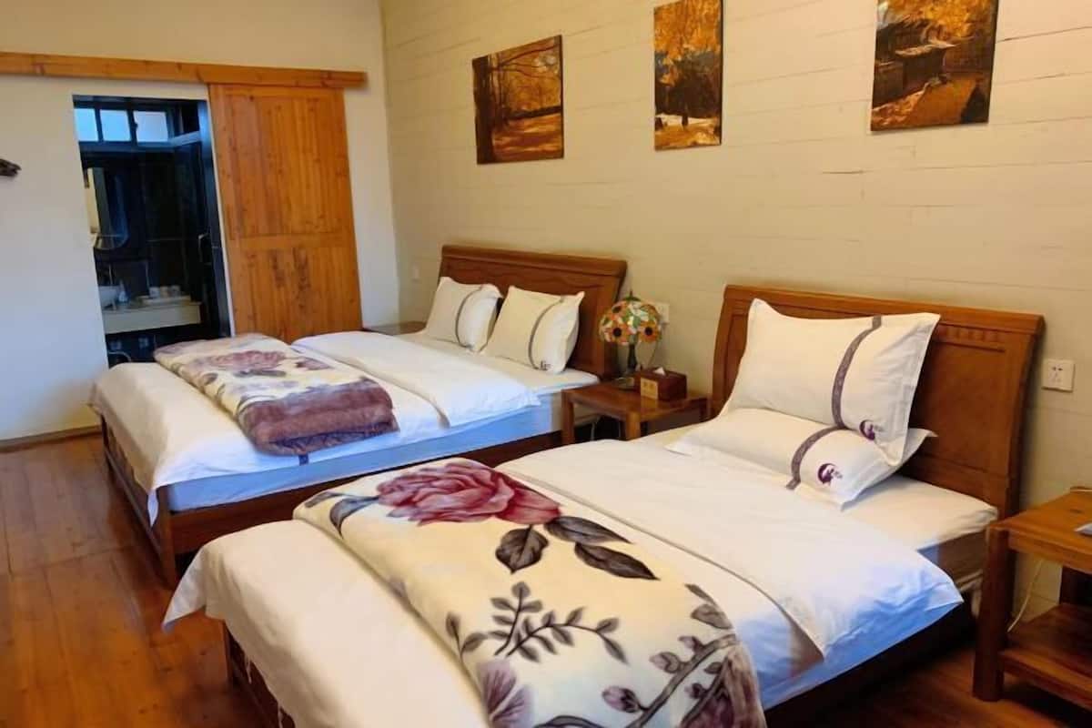 A room with two beds, wooden headboards, and a wooden wardrobe.