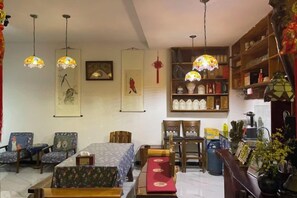 Une pièce de style traditionnel comprenant un coin repas, une bibliothèque et des lampes suspendues.