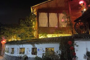 Un edificio tradicional con fachada de madera, un ventanal grande y una estructura decorativa en forma de rueda.