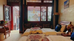 Habitación tradicional con dos camas, un escritorio y vistas al exterior.