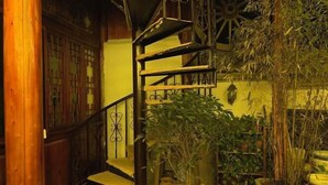 Una escalera en espiral con baranda de madera y plantas en macetas.