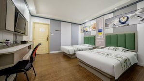 Une chambre d’hôtel avec un lit, un bureau, une chaise, une télévision et une porte.