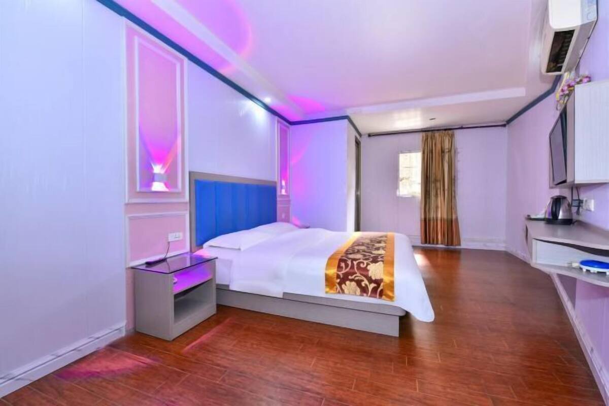 Ein Hotelzimmer mit Bett, Nachttisch und Fernseher.