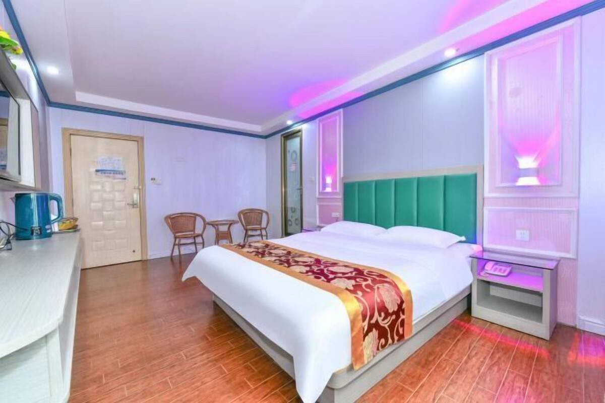 Ein Hotelzimmer mit Bett, Nachttisch und Schreibtisch mit Stuhl.
