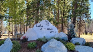 A large rock with 'Lake Almanor West' engraved on it, surrounded by smaller rocks and greenery. - Lake Almanor West home in a peaceful setting just minutes from the lake (Chester)