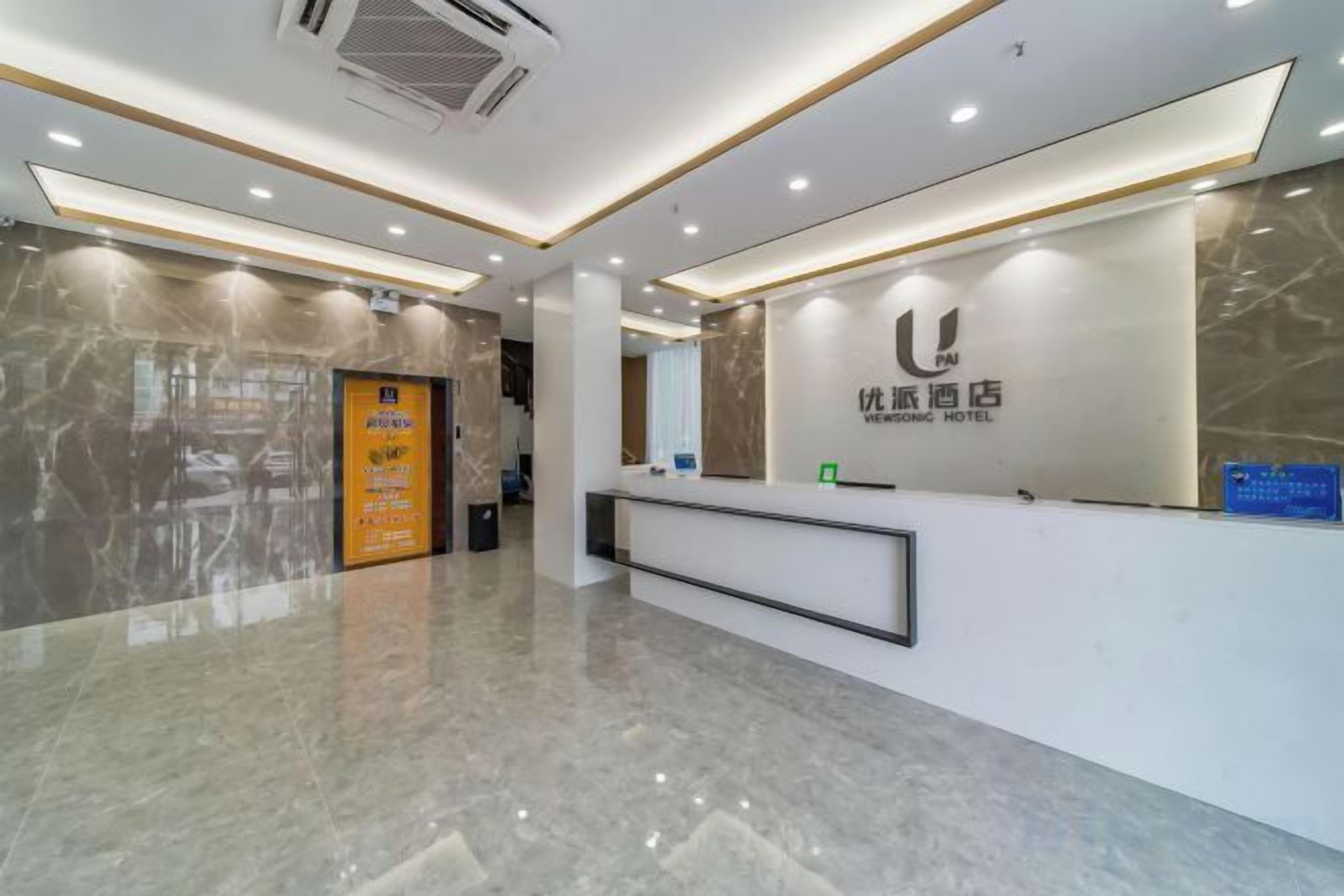 A hotel reception area with a marble floor, a reception desk, and a wall-mounted sign.