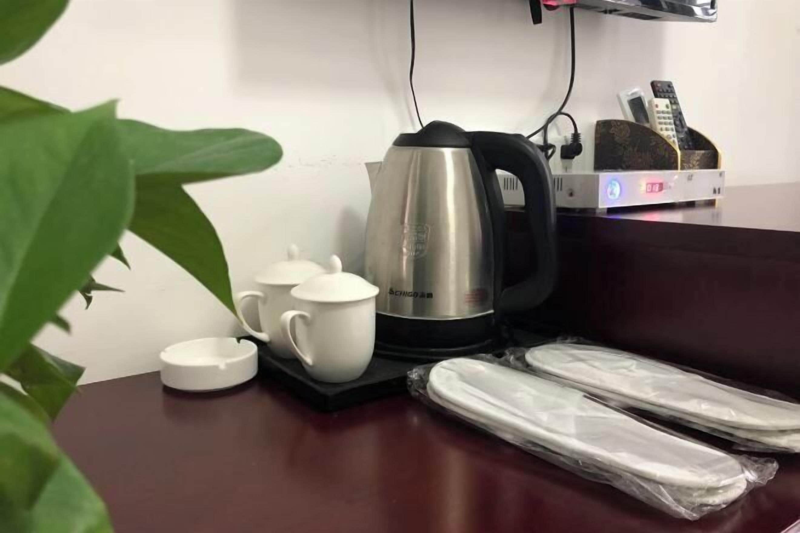 Uma mesa com chaleira, chávenas e suporte para comando.