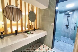 A bathroom with a white sink, two mirrors, a shower, and patterned floor tiles. - Lanyu Inn (Yichang Three Gorges Dam) (Yichang)