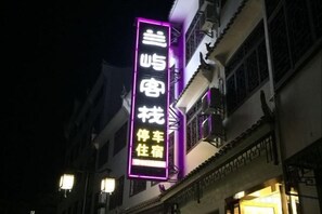 Un edificio con un letrero de neón que indica un restaurante o lugar para comer.