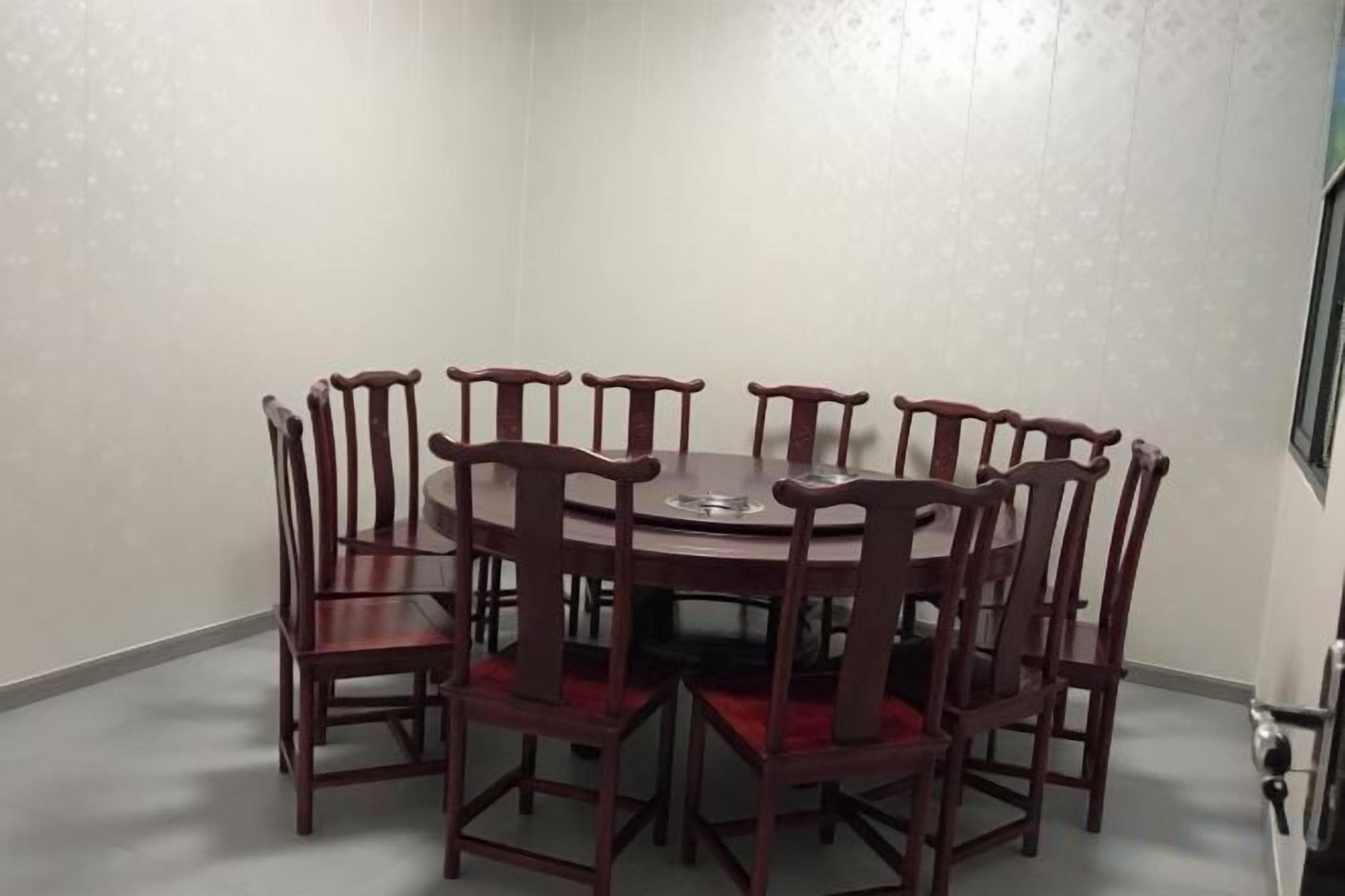A dining area with a round table and eight wooden chairs.
