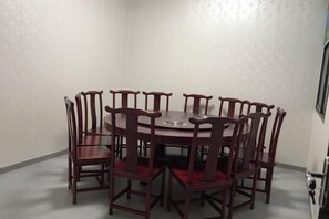 Un comedor con una mesa redonda y ocho sillas de madera.
