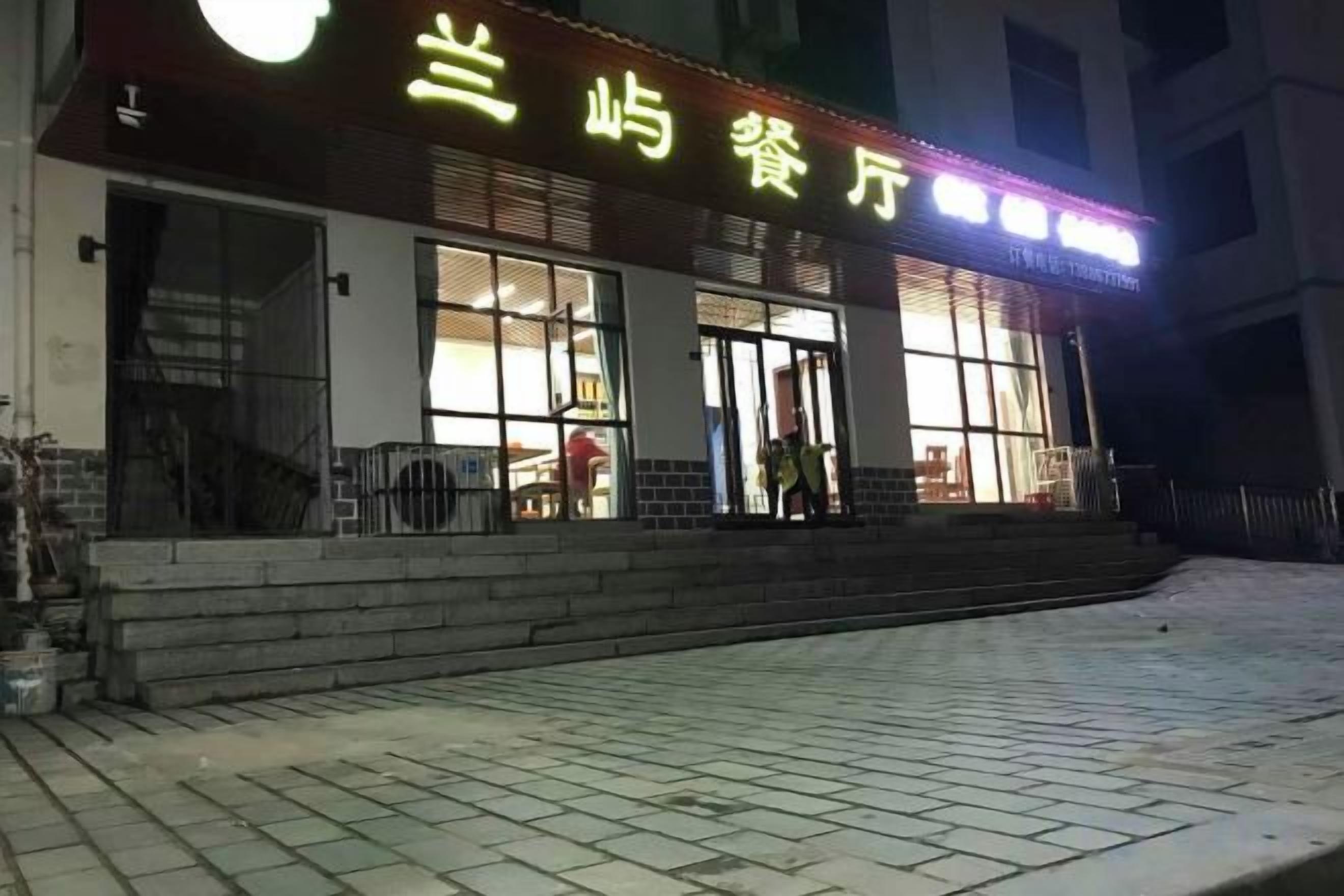 A building with a sign that reads '兰崎餐厅' and a staircase leading to the entrance.
