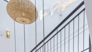 A modern interior with a staircase, a woven light fixture, and a neon sign. - Studio Glamour Rose Alicante (Alicante)