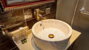A bathroom with a large marble sink, a towel rack, and a mirror. - Yongyichang Inn (Pingyao County)
