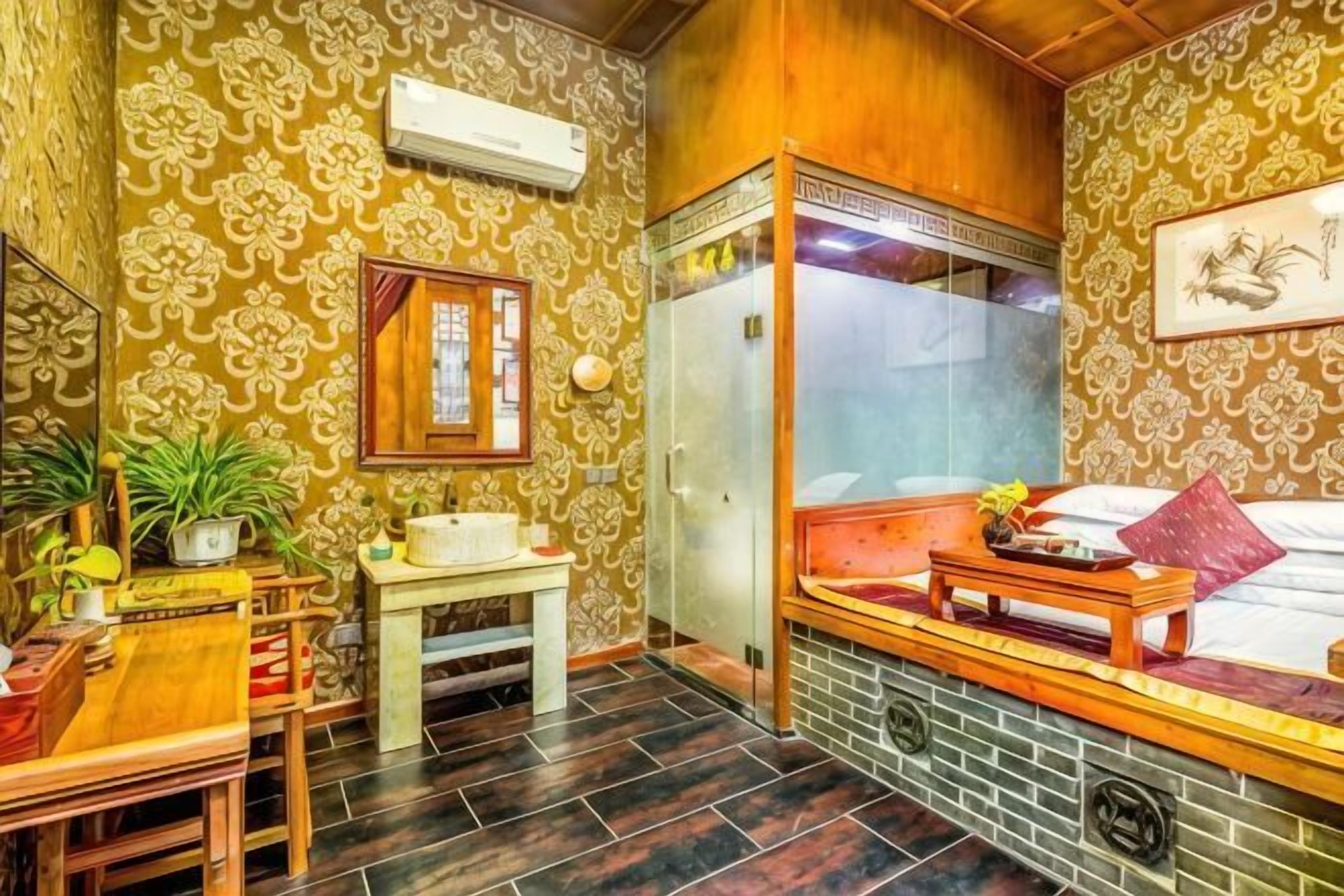 A room with patterned wallpaper, a wooden bench, a small table, a mirror, and a window.