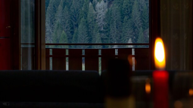 A room with a large window overlooking a forested area. - HOTEL MAE' (Val di Zoldo)