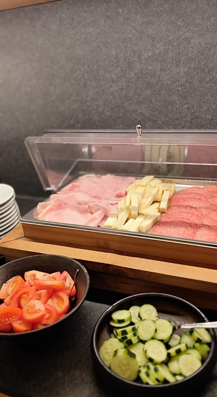 A buffet with sliced meats and vegetables.
