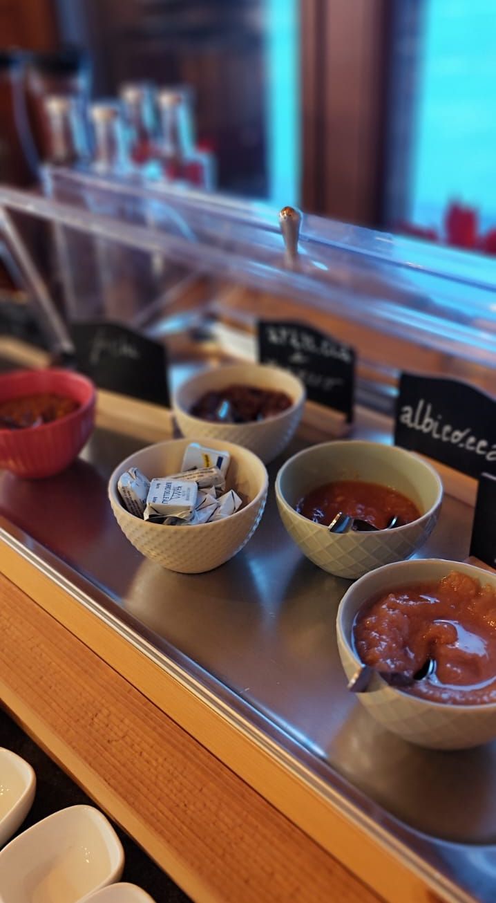 A display case with various food items, including bowls of condiments and packaged goods.