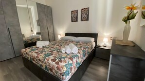 Una camera da letto moderna con un letto grande, un comodino con una lampada e uno specchio.