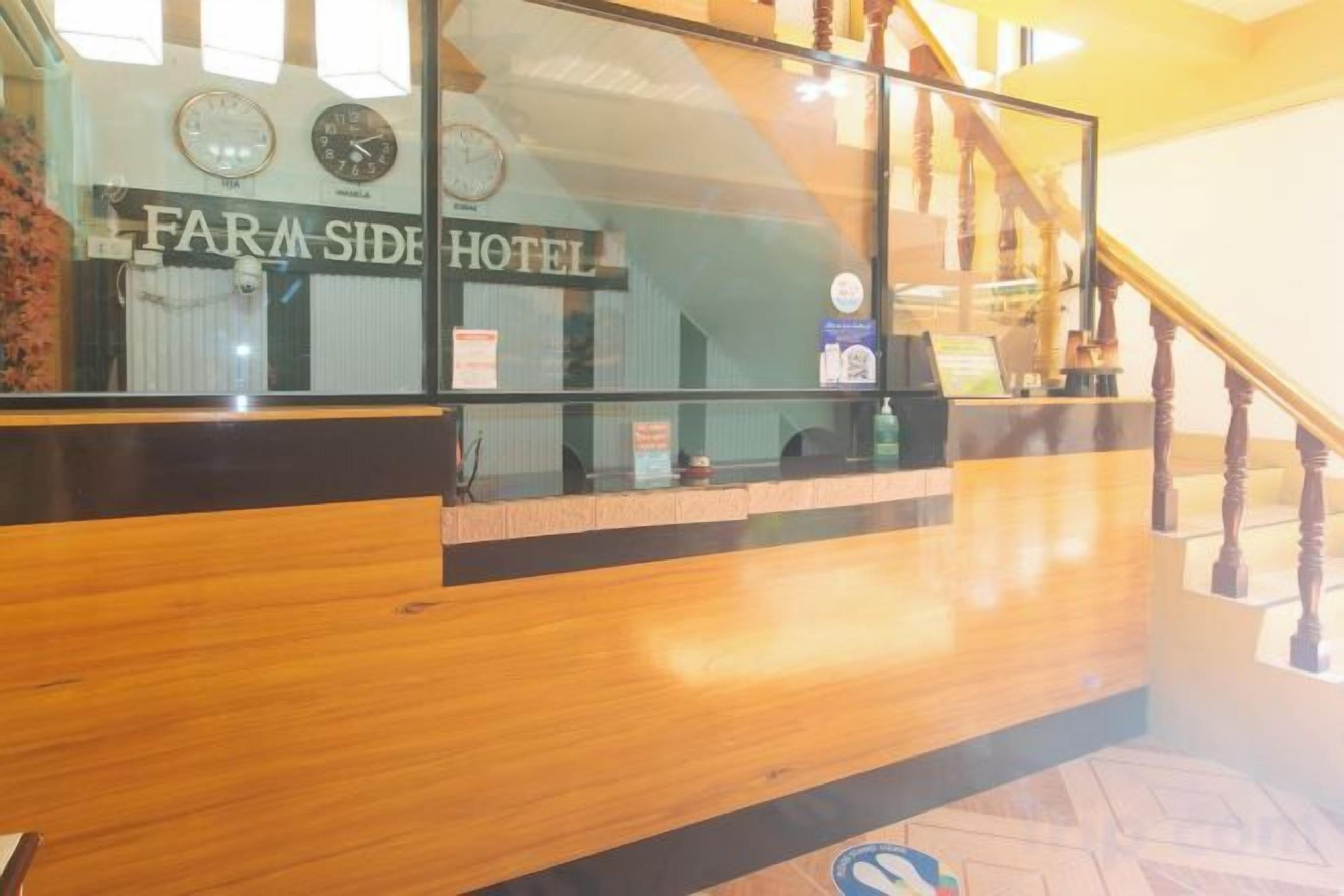 Un espace d’accueil avec un comptoir en bois, une fenêtre en verre et un escalier doté d’une rampe en bois.