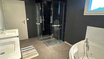 Douche, baignoire Ă jets, sĂšche-cheveux, serviettes fournies