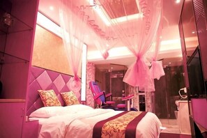 A bedroom with a bed, a chair, a vanity, and a shower area. - Aishang Boutique Hotel (Cixi)