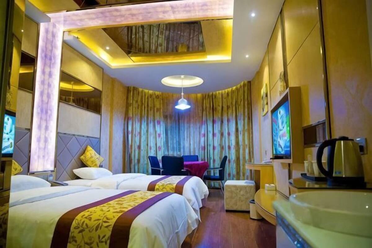 Une chambre d’hôtel avec un grand lit, un bureau avec des chaises, une télévision et une machine à café.