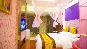 Ein Schlafzimmer mit Bett, Fernseher, Spiegel und Fenster.