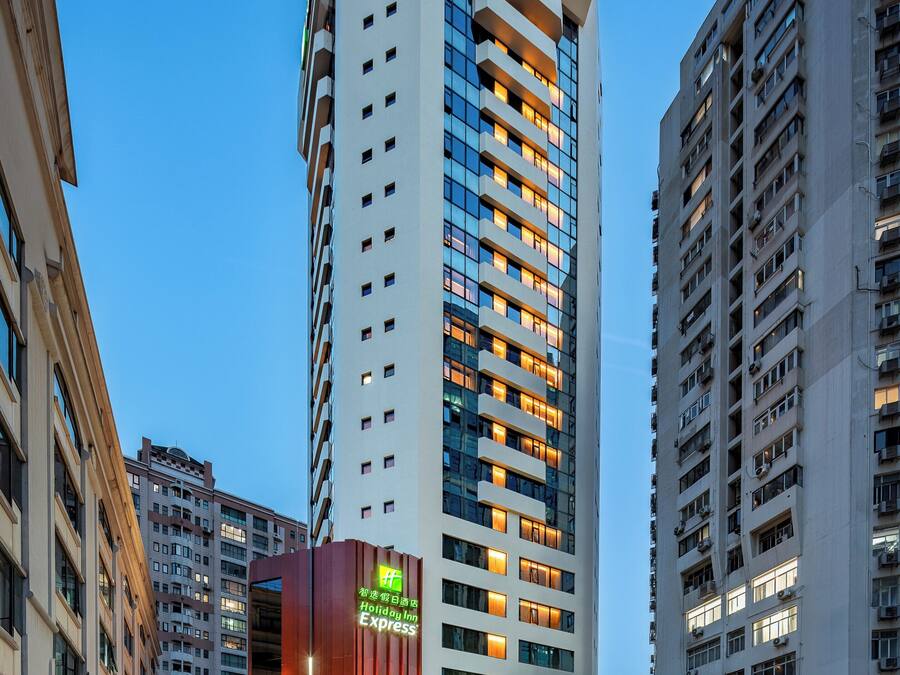 Un edificio de hotel alto con un diseño moderno, que presenta un letrero llamativo de 'Holiday Inn Express'.