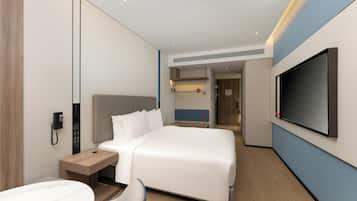 Een moderne hotelkamer met een groot bed, een nachtkastje, een aan de muur bevestigde televisie en een telefoon.