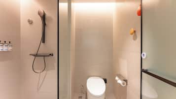 A modern bathroom with a glass shower enclosure, a toilet, and a glass partition.
