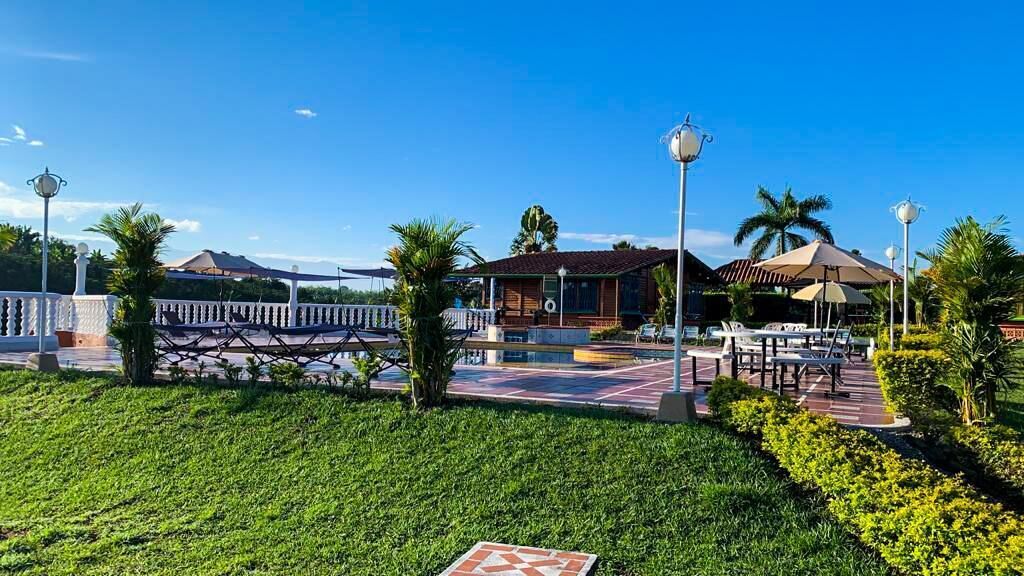 A hotel with a pool area, outdoor seating, and a well-maintained garden.