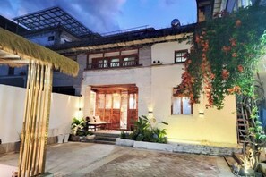 A traditional building with a wooden door, a balcony, and a staircase leading to the entrance. - Zuji Youth Hostel (Dali City)