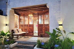 A wooden entrance with a bench and steps leading to a covered area. - Zuji Youth Hostel (Dali City)