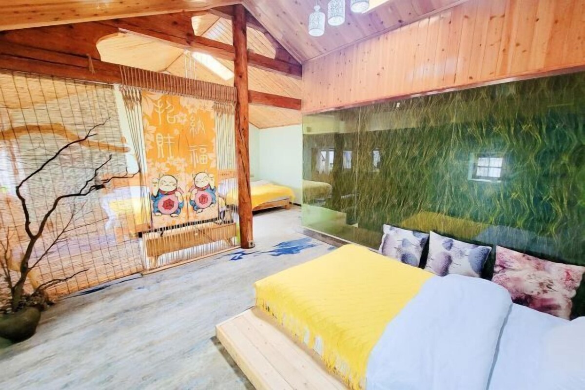 A room with a bed, a green textured wall, a wooden ceiling, and a decorative screen with artwork.