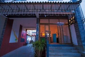 A hotel entrance with a glass door, steps leading up to it, and a sign above the door. - Zuji Youth Hostel (Dali City)