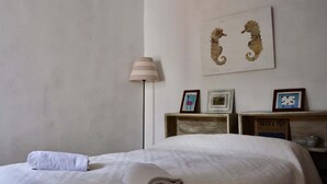 Een hotelkamer met een bed, een lamp en wanddecoratie.