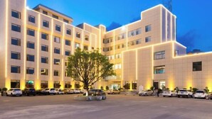 Ein modernes Hotel mit Innenhof, mehreren Etagen und Parkplatz.
