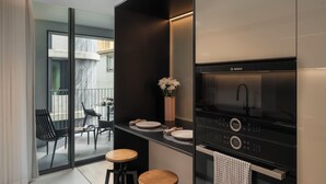 Une cuisine moderne équipée d’une cuisinière Bosch, agrémentée d’un vase de fleurs et comprenant un coin repas avec des chaises et une table.