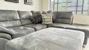 Ein modulares Sofa mit einem Zierkissen in einem Zimmer mit Fenster.