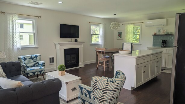 A spacious living room with a fireplace, a television, and a dining area.