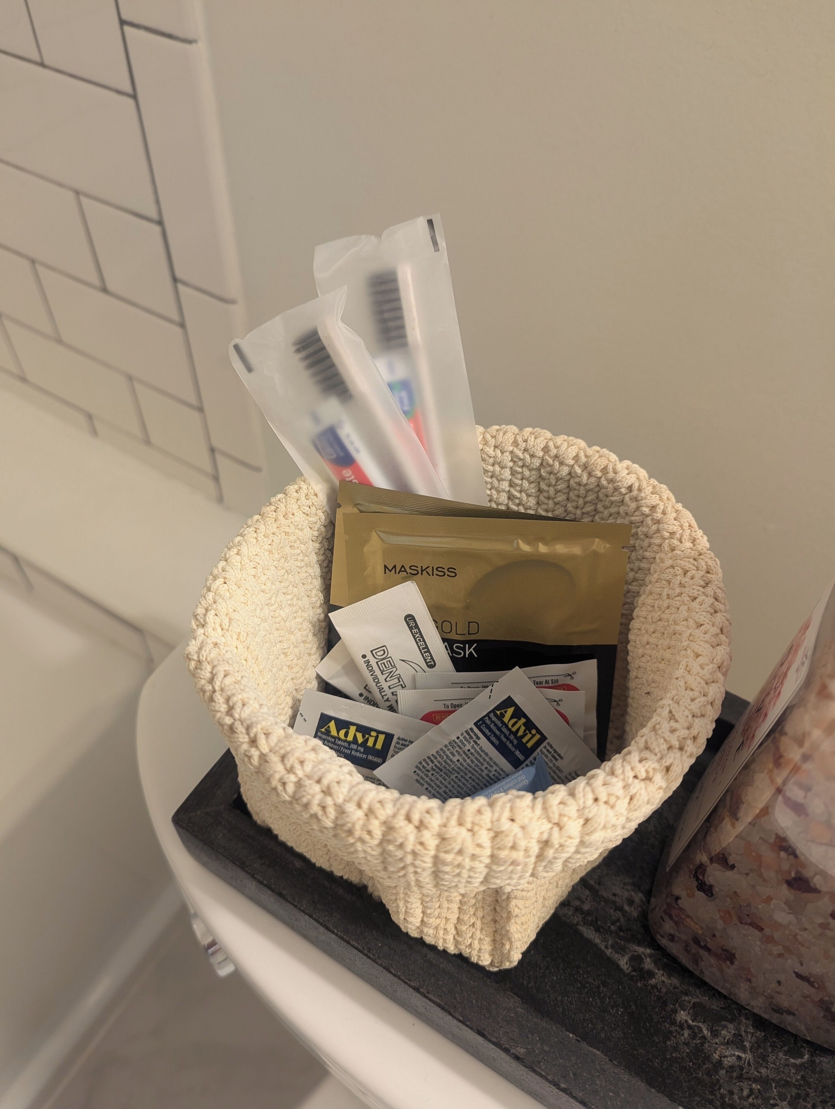 Un panier rempli de produits d’hygiène bucco-dentaire, notamment un masque et divers produits dentaires, est posé sur un comptoir.
