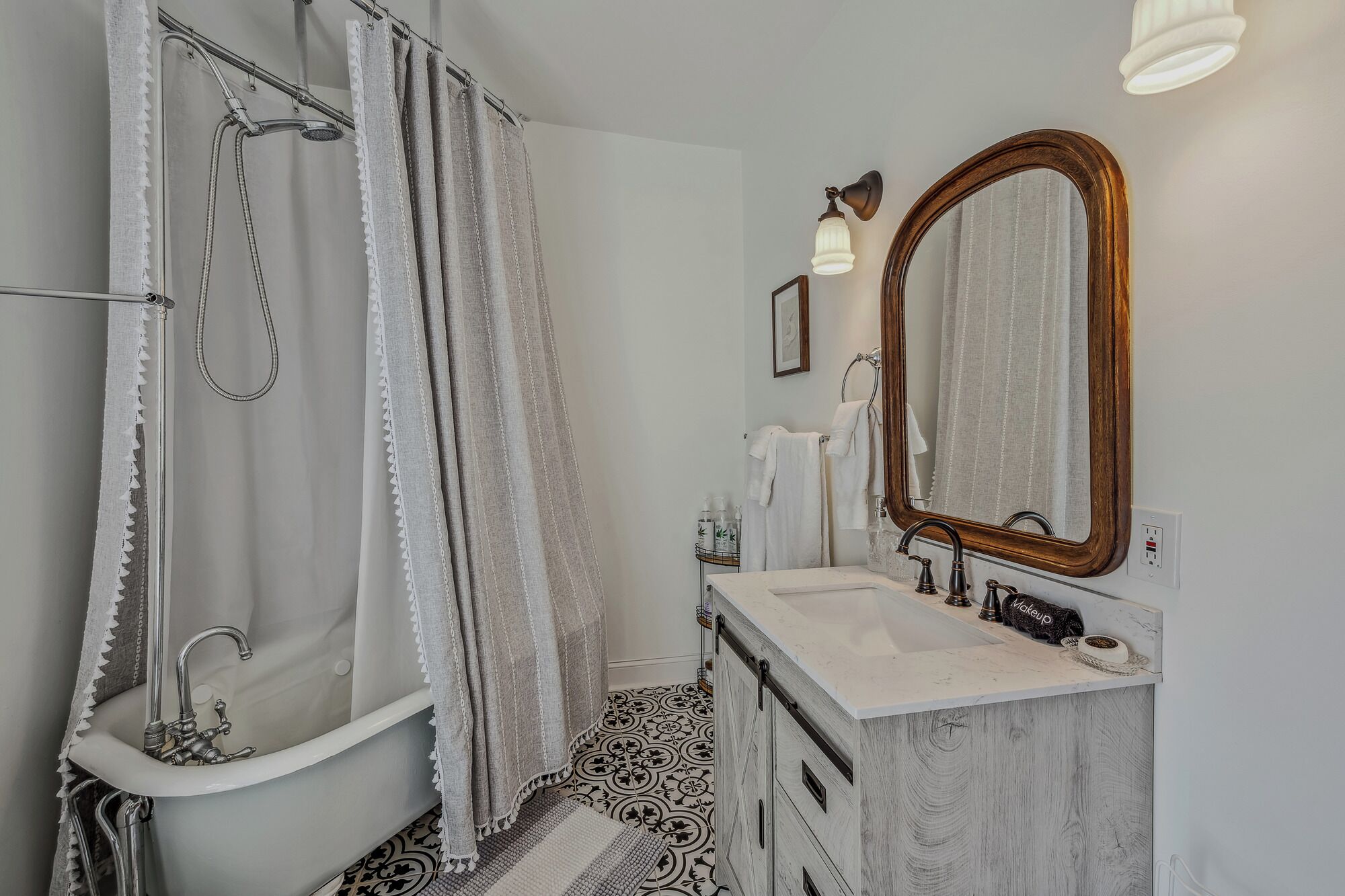 A bathroom with a shower, a sink, a vanity, and a large mirror.