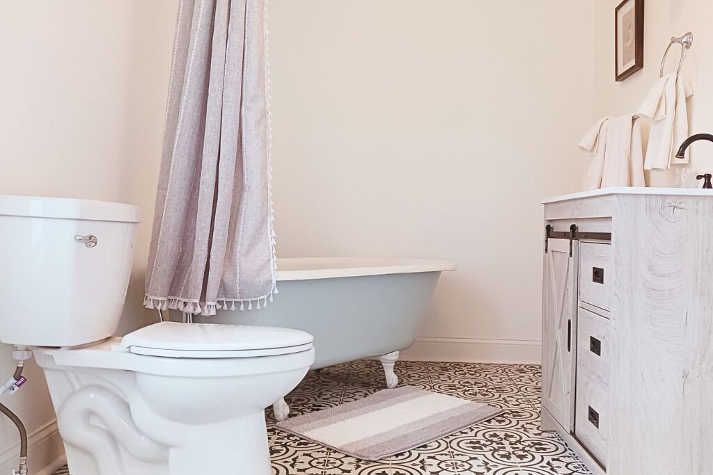A bathroom with a toilet, a bathtub, and a cabinet.