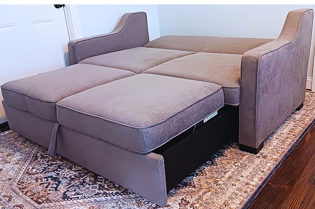 Ein modulares Sofa mit flachem Design, einem integrierten Stauraum und einem gemusterten Teppich.