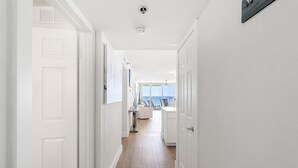 A hallway with white doors, wooden flooring, and a view to the outside. - STEPS TO THE BEACH!!! Beautifully Renovated Unit w/Breathtaking Views (Miramar Beach)
