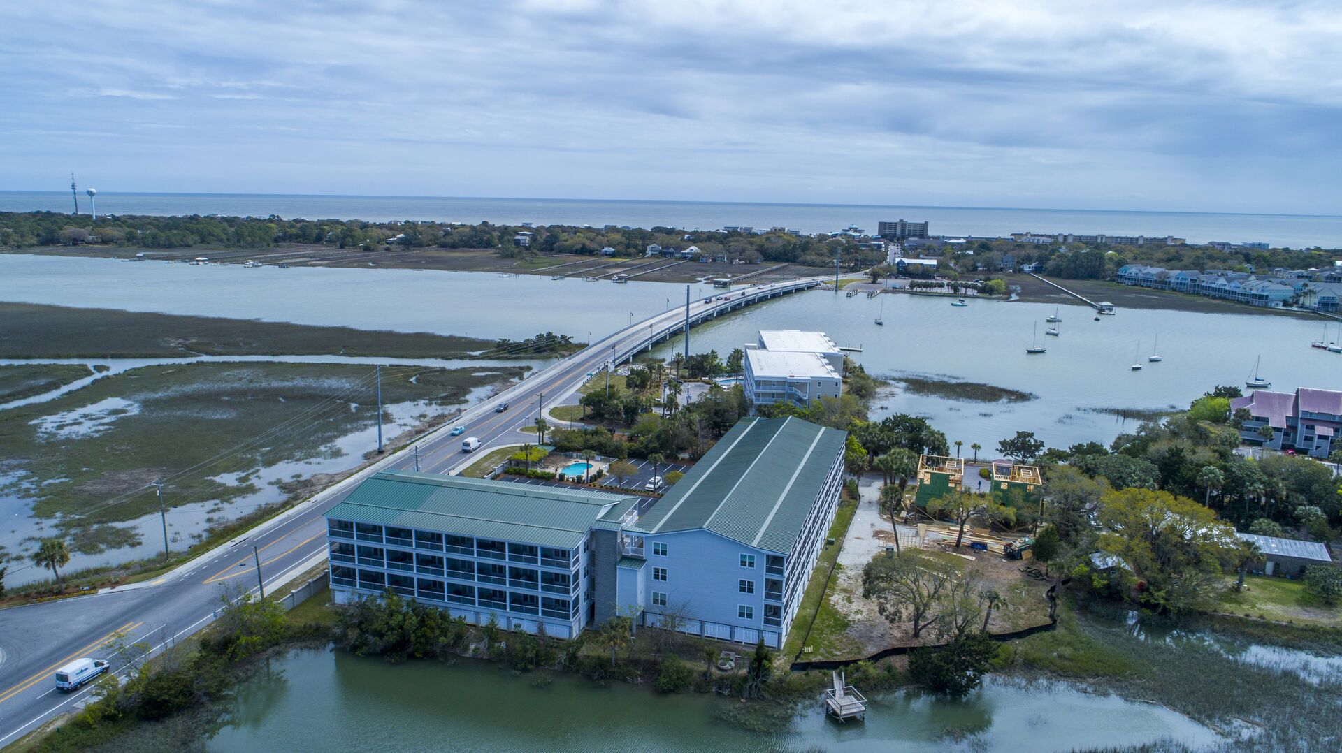 A coastal area with a large building, a bridge, and a marina with boats.