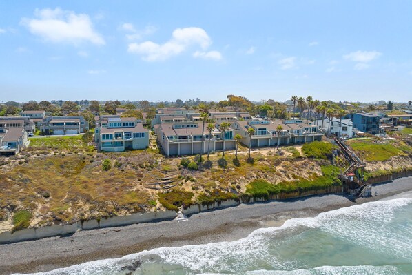 A coastal residential area with modern houses, a beach, and a rocky shoreline. - Picturesque Perfection in Leucadia (Encinitas)